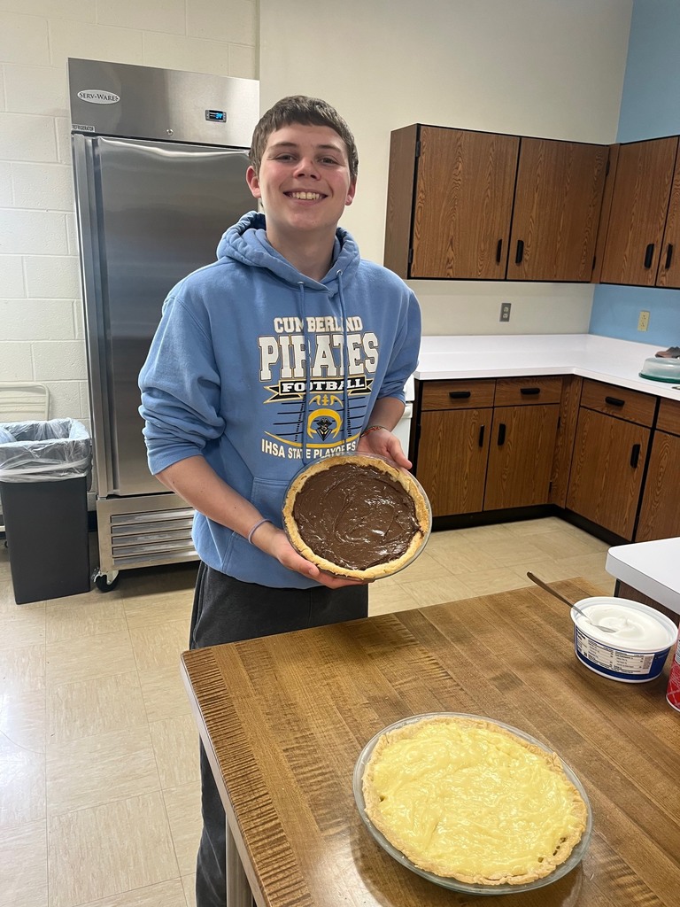 One student is holding his finished chocolate pie. 
