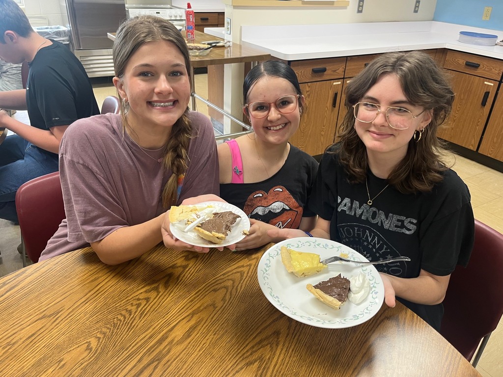 Three students are showing their two plates of crust. 