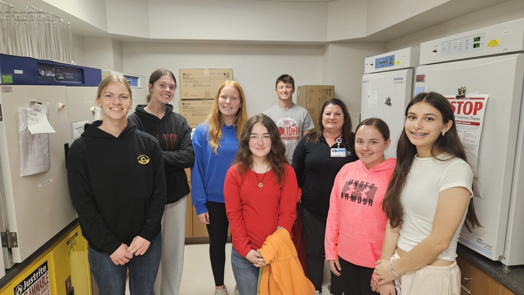 Seven students and the lab technician are pictured in the lab. 