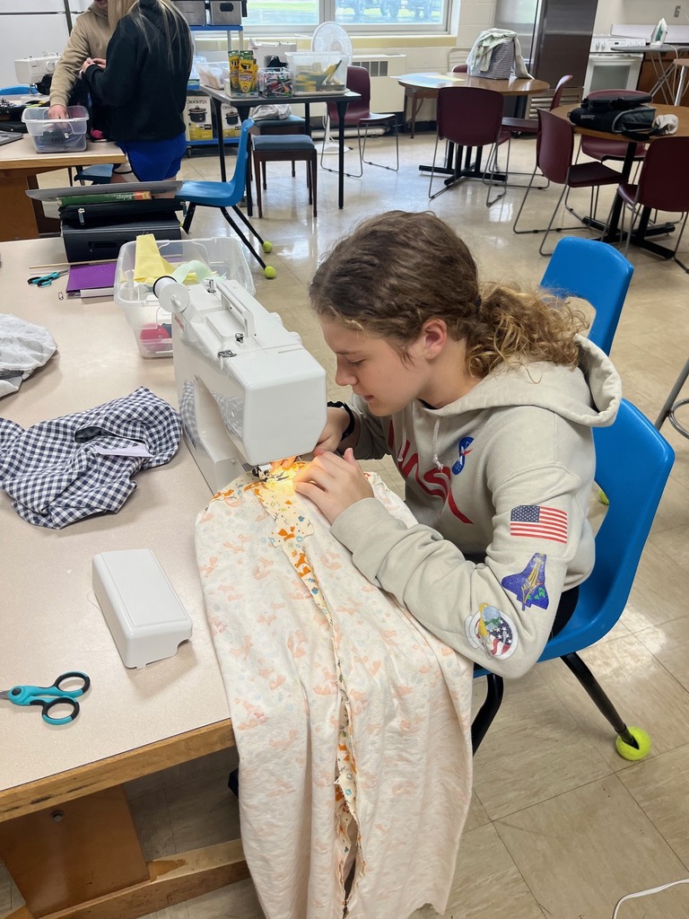 One student is sewing on a sewing machine. 