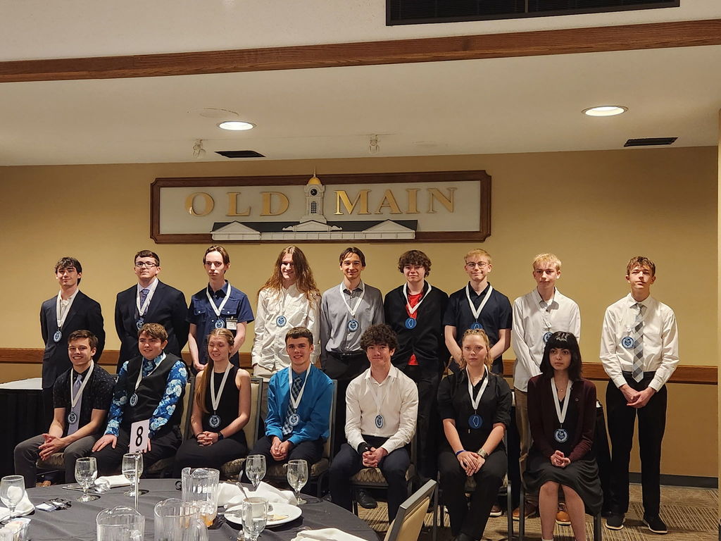 Nine of the first team and seven of the second team awardees are pictured with their medals. 