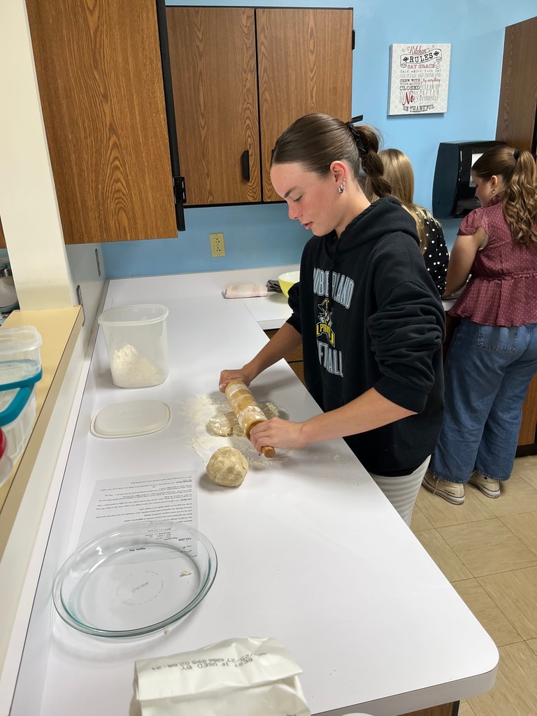 A student is rolling dough. 