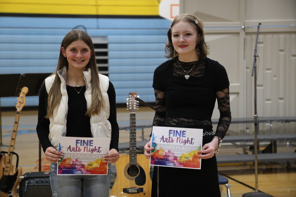 Two of the Fine Arts Night show winners are standing with their certificates. 