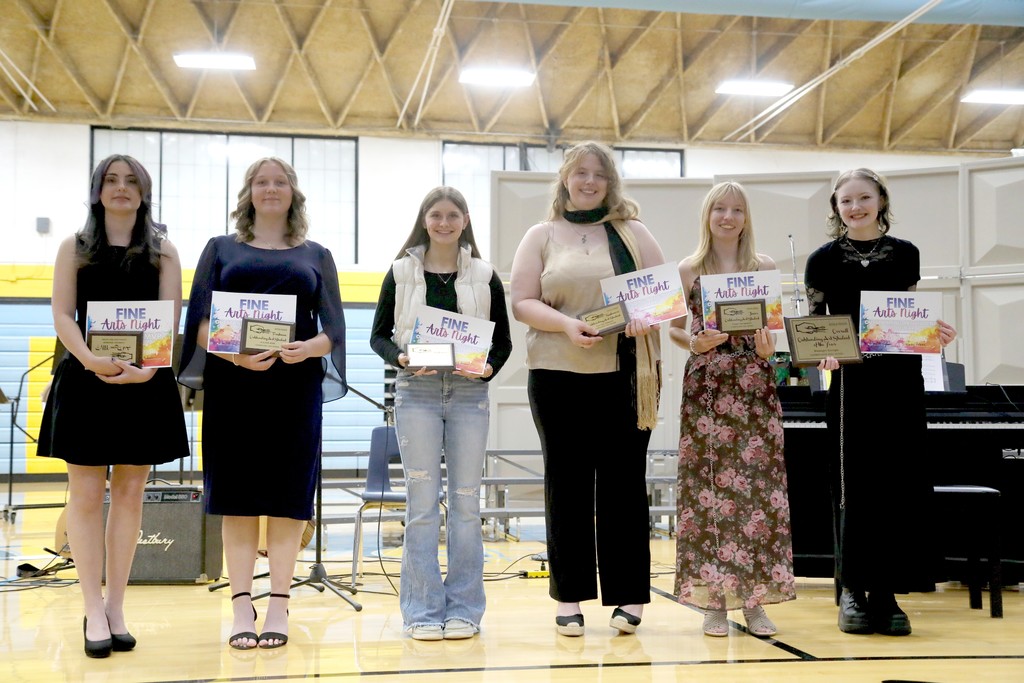 Six of the outsanding art student winners are staning with their plaques. 