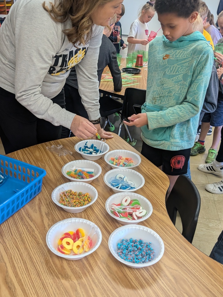 A teacher is helping a student pick out a candy for the drink.