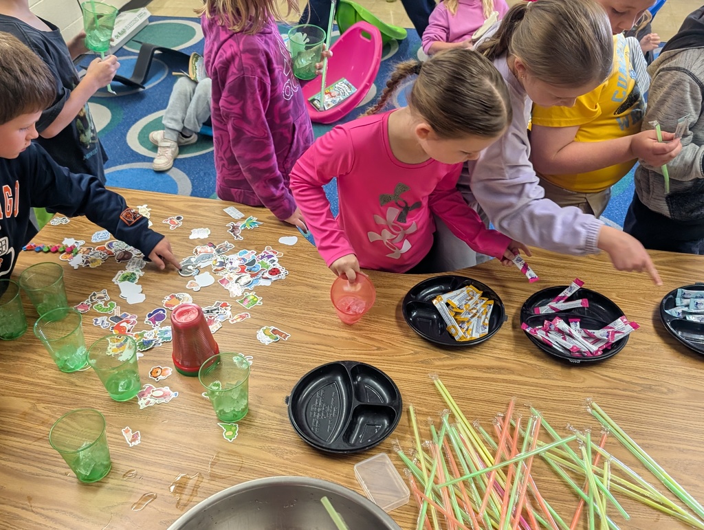 Three students are picking out stickers for cups and drink packets. 