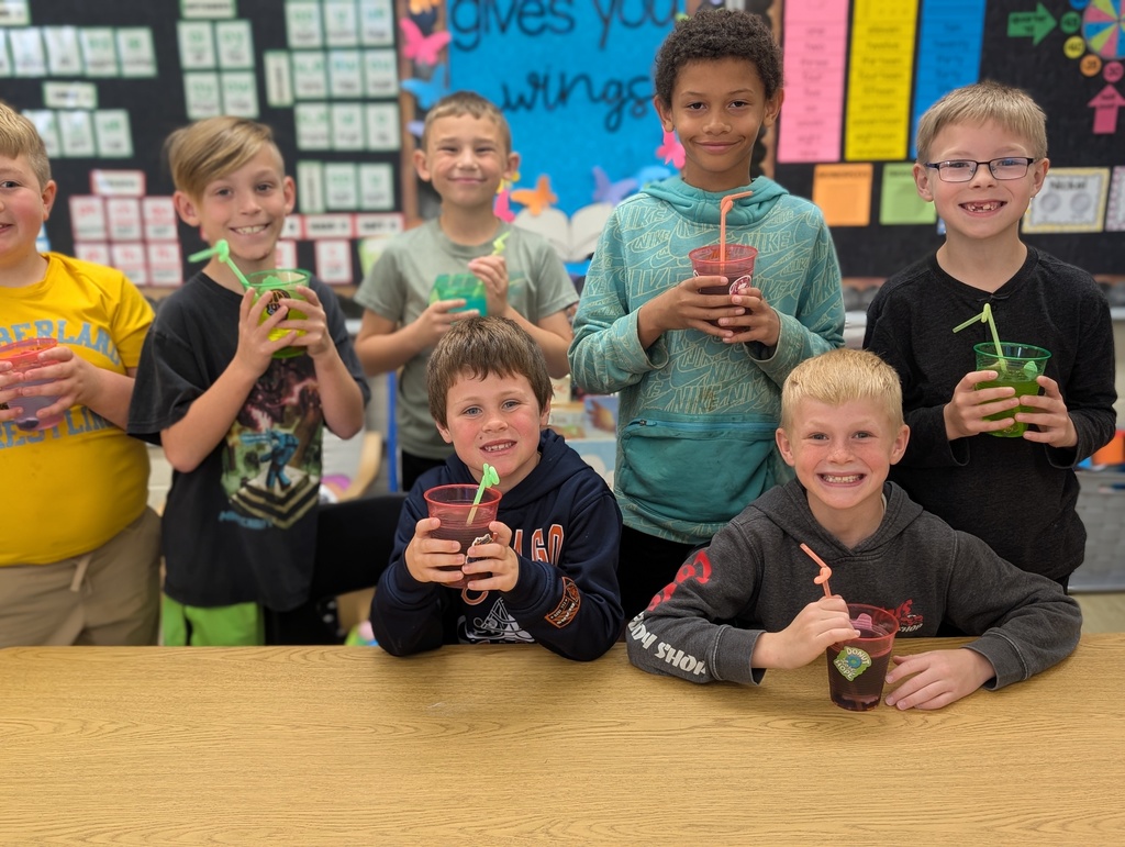 Seven studetns are together showing their drinks with fancy straws and stickers. 
