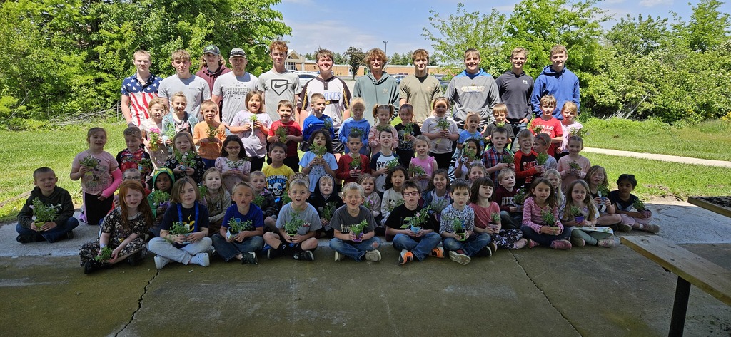 Pictured are the students, each holding a flower, and the FFA students who helped plant the flowers. 