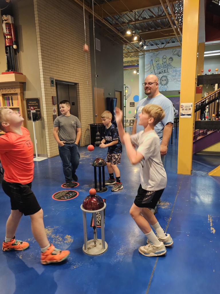 Students are cathing a ball at the STEM exhibit.