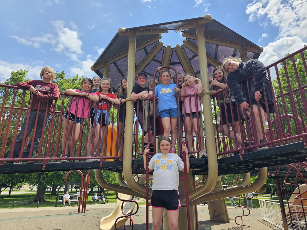Several students are posing for a picture at the jungle gym.