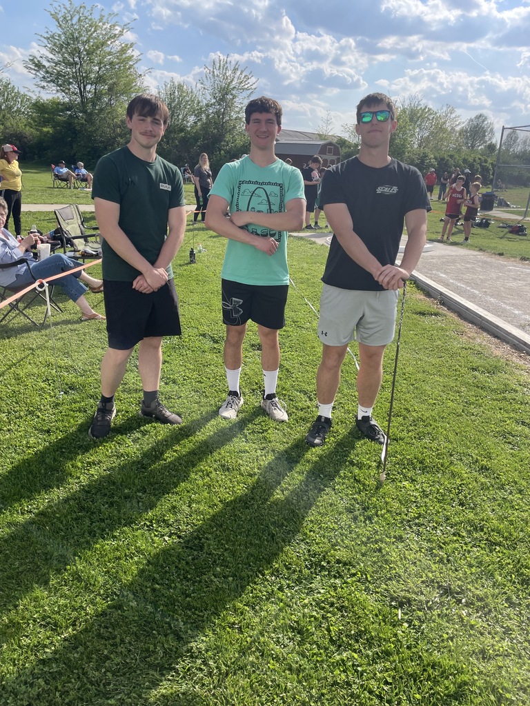 Three Cumberland students are helping run an event at a track meet. 