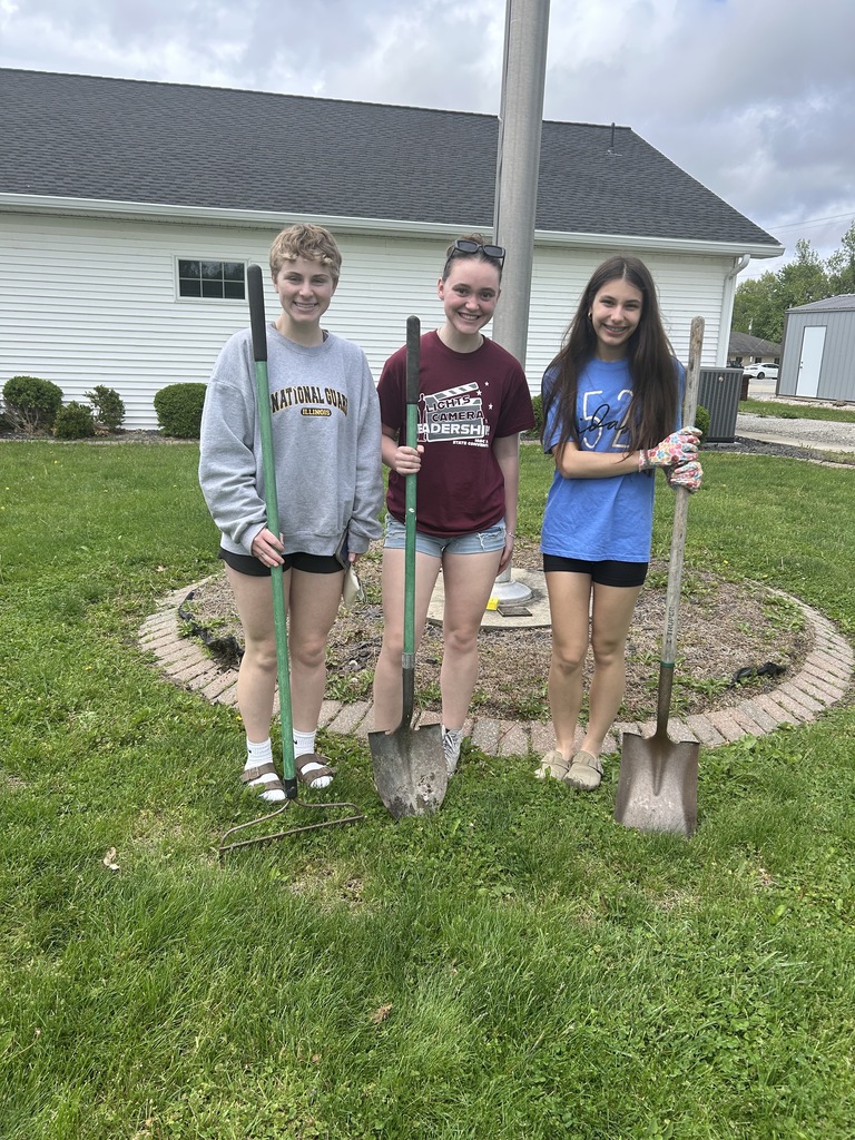 Three Cumberland students are standing with shovels at their volunteer activity. 