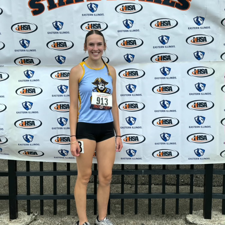 The runner is pictured in front of the IHSA banner  