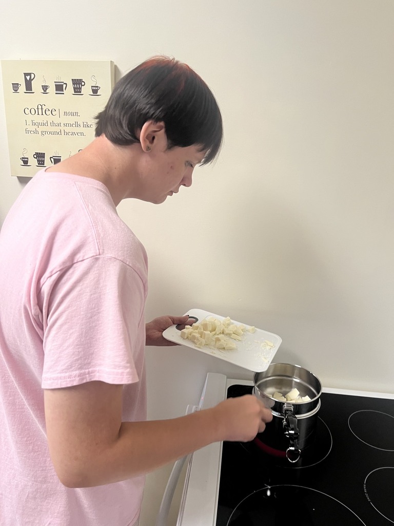 A student is adding white chocolate to a double broiler. 