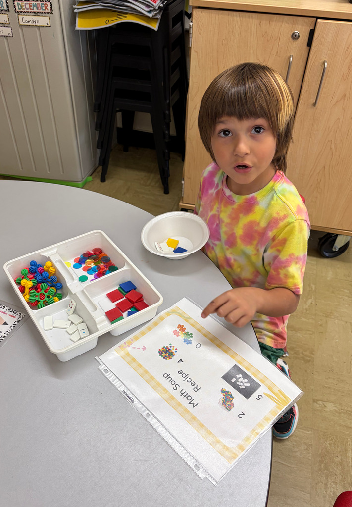 A student is filling a bowl with items to make number soup.