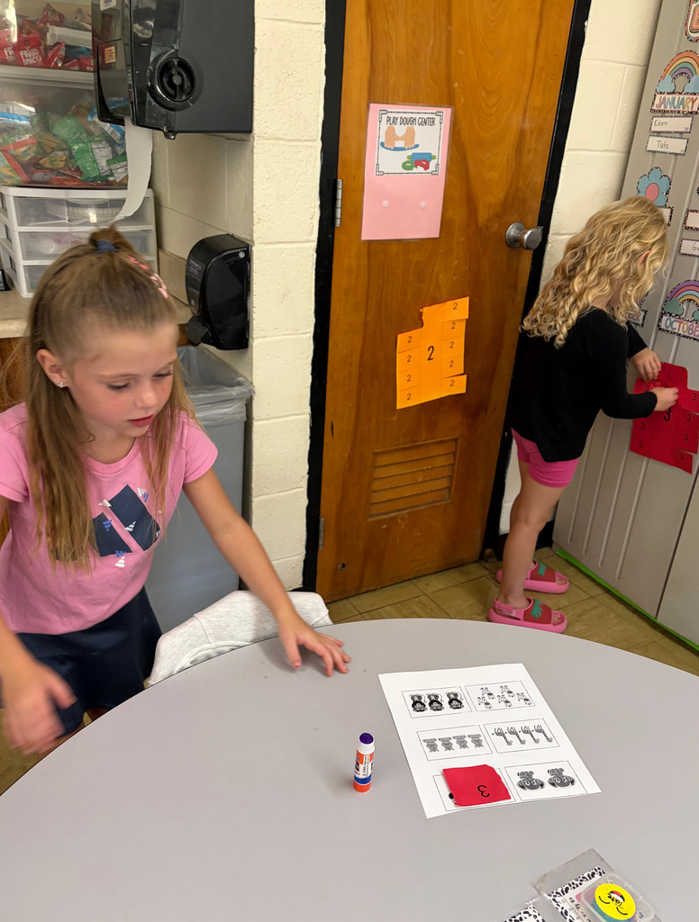 Two students are matching a number to an amount of items