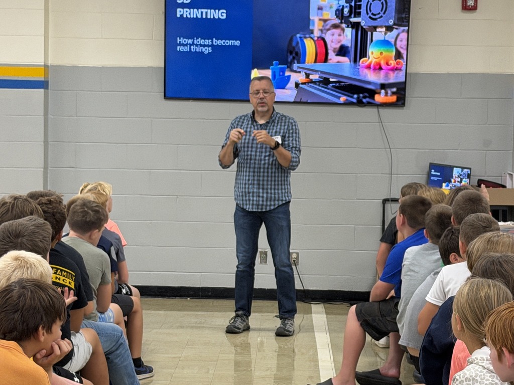 Mr. Rhine is standing in front of the students explaining 3D printing.