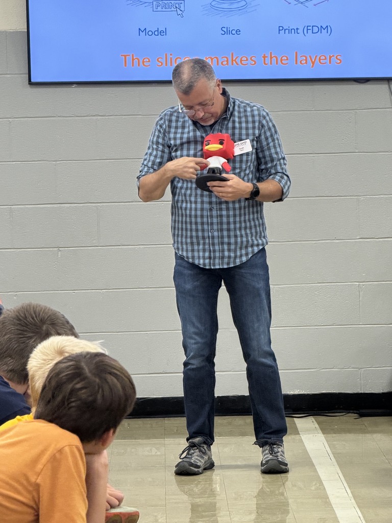 Mr. Rhine is showing one of the 3D printed objects. 