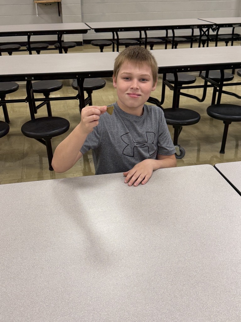 A student is holding up their 3D printed souvenir. 