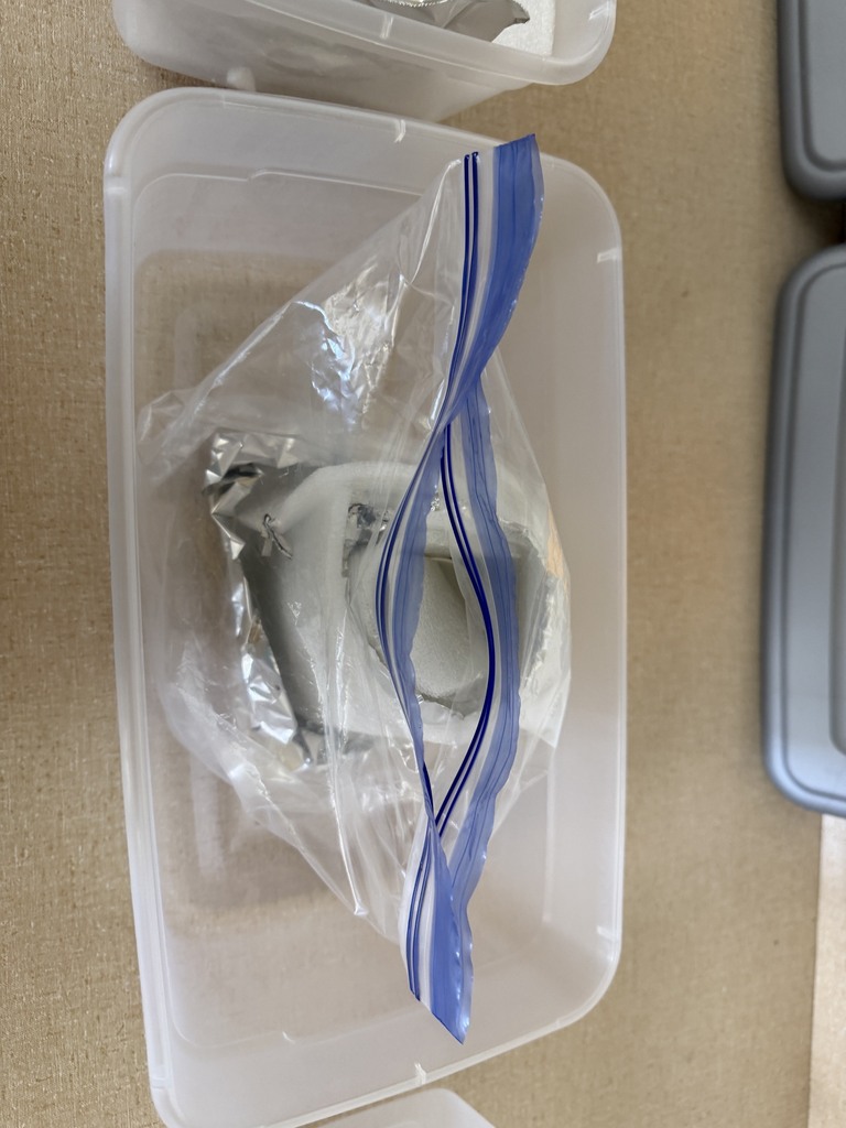 A cup is covered in foam, aluminum foil, and in a baggie.
