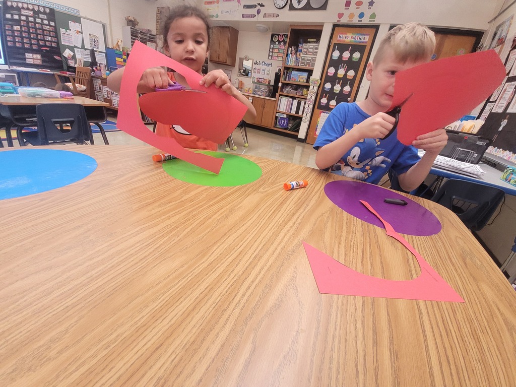 Two students are cutting apple shapes. 