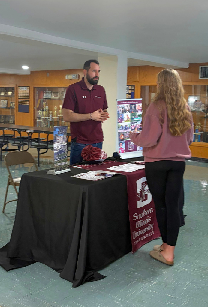 A student is speaking to a college representative. 