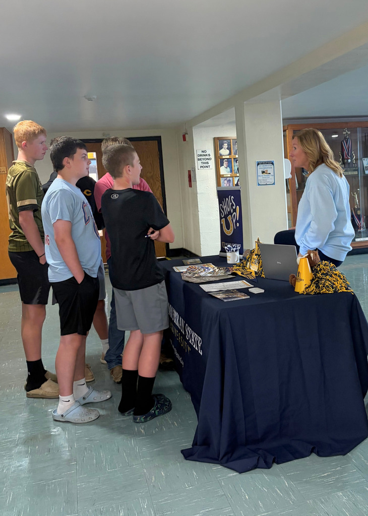 Five students are speaking to a college representative. 