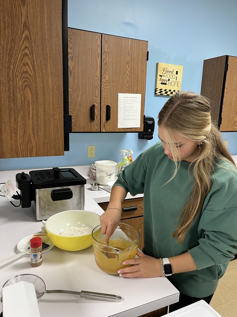 A student is mixing ingredients in a bowl.