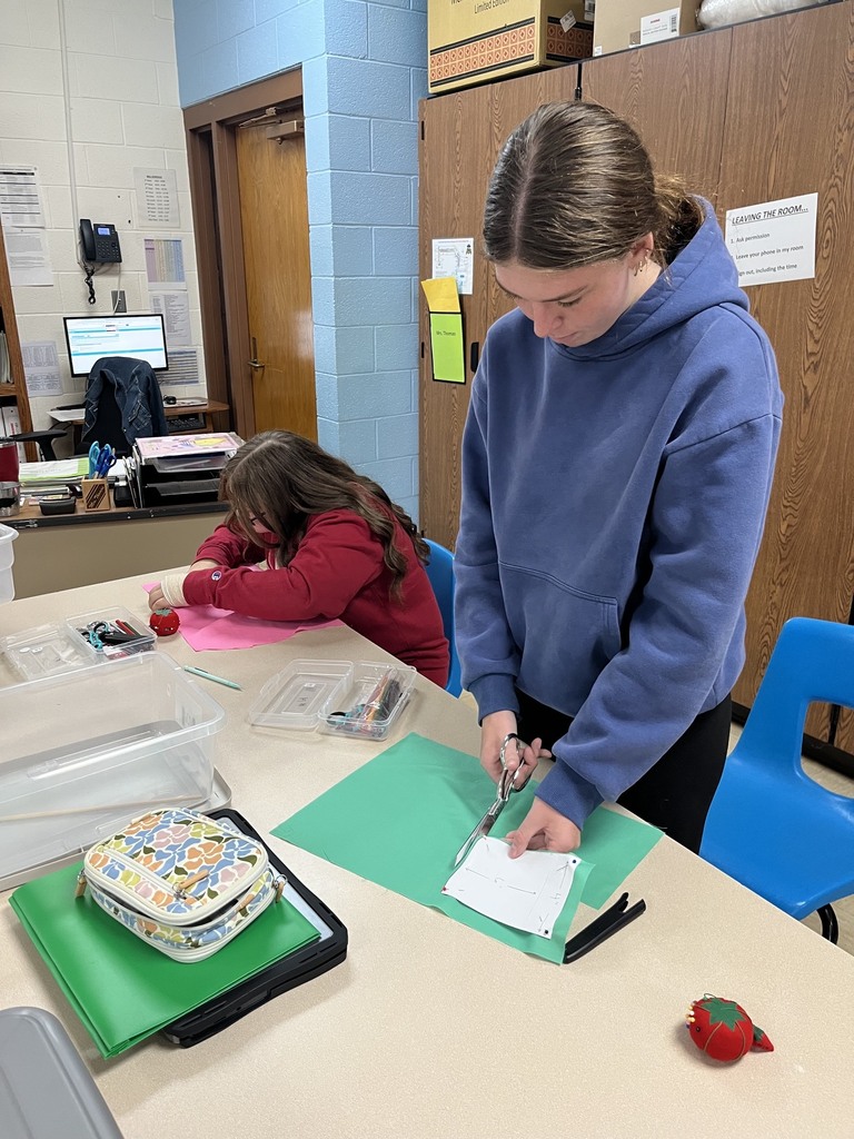 Two students are cutting out their fabric.