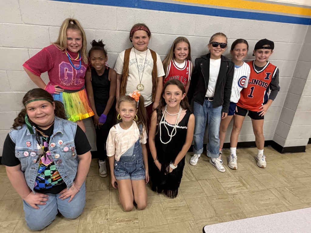 Ten students are dressed in decade-themed outfits. 