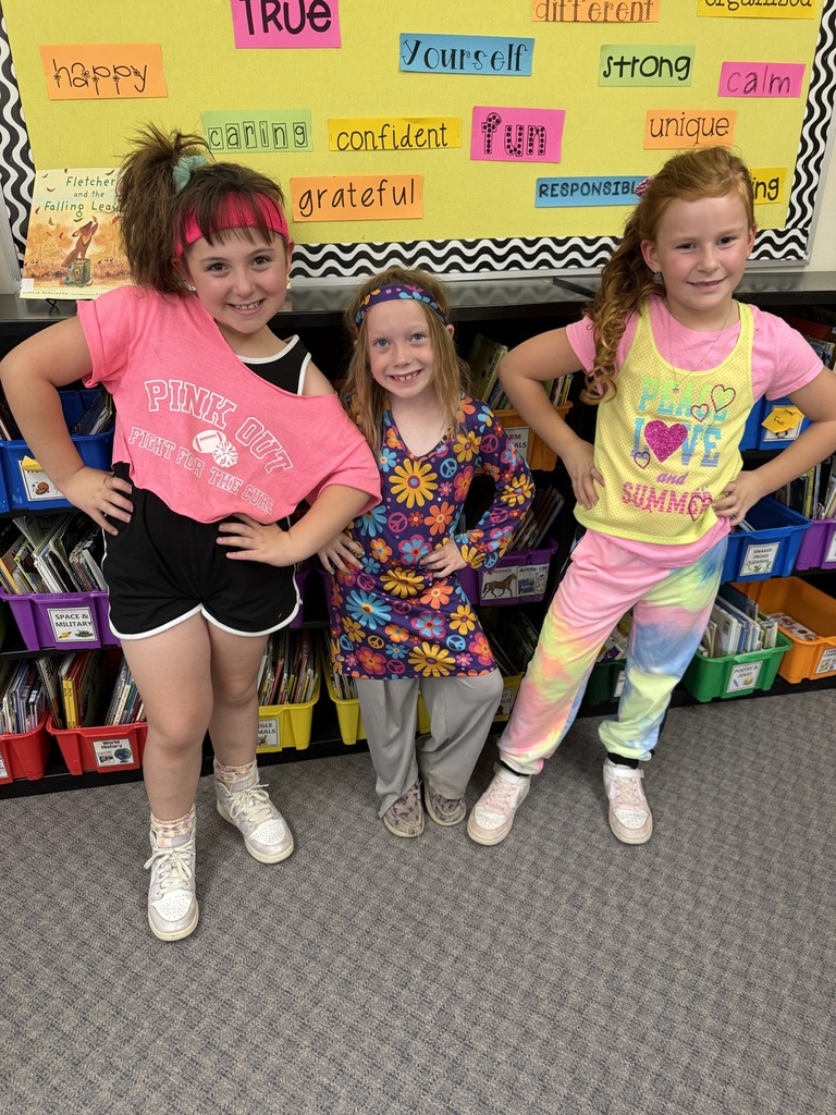 Three students are dressed in decade-themed outfits. 