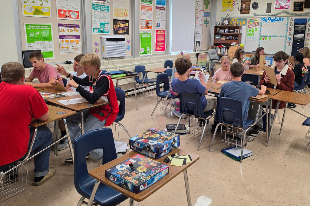 Students are sittign in groups of 4-5 playing the game.