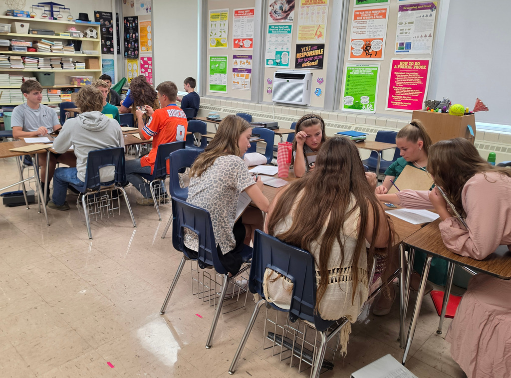 Students are sittign in groups of 4-5 playing the game.