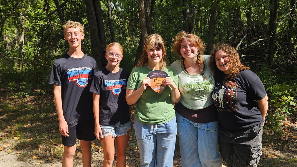 Five members are standing their plaque. 
