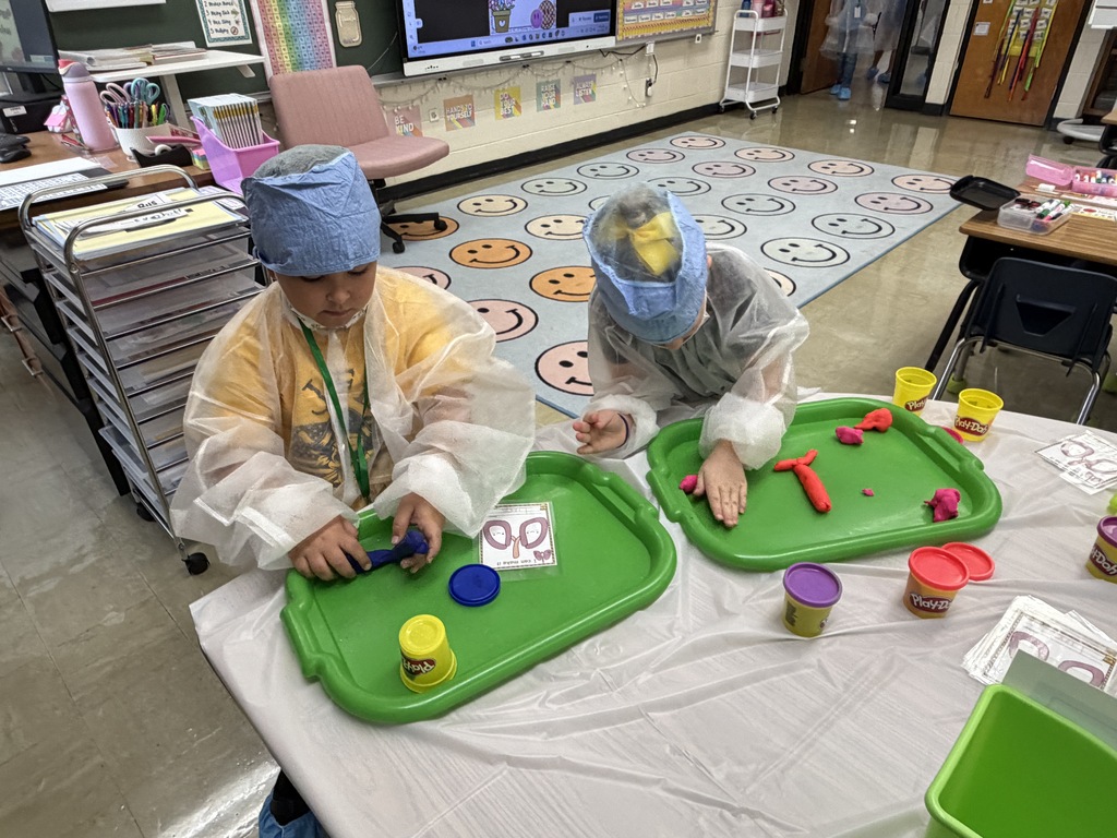 Two students are using play-doh to create a set of lungs.