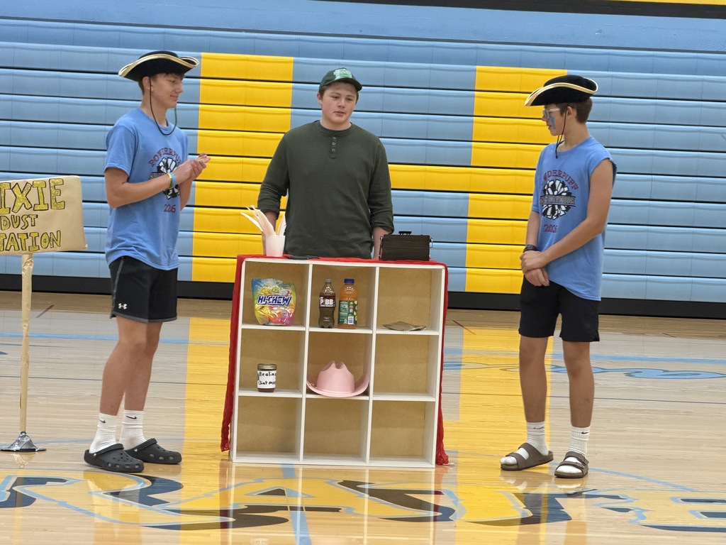 Three students are doing a skit. One is a convience store worker and two are pirates visiting the store. 