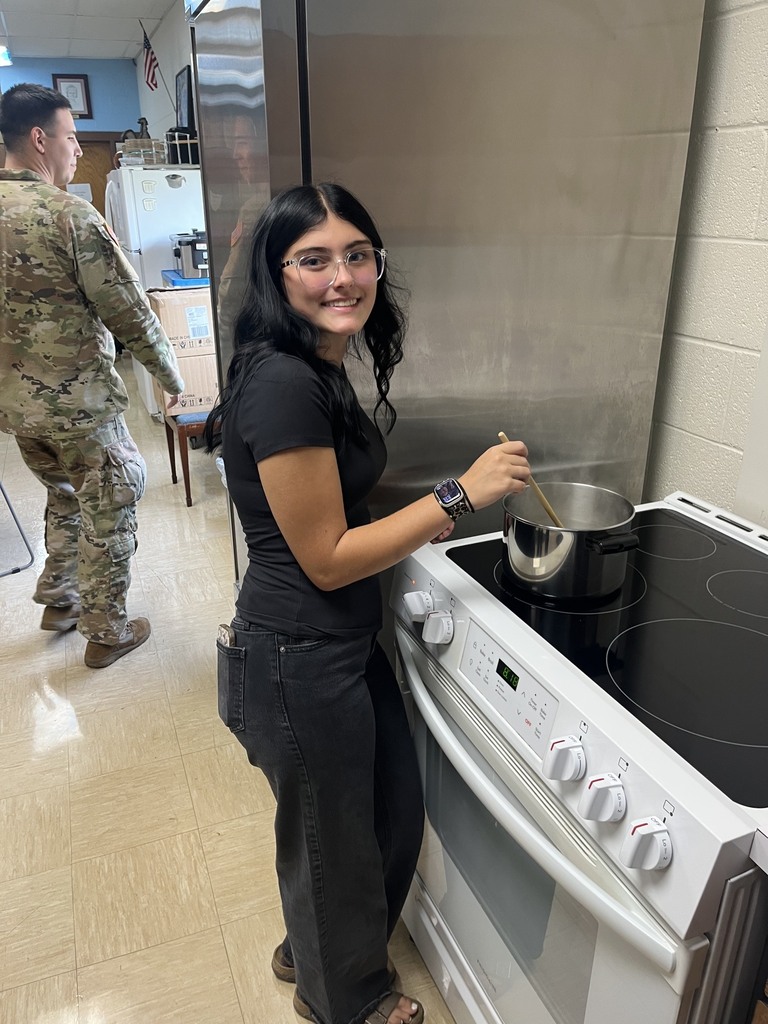 A student is stirring the MRE in a pan.