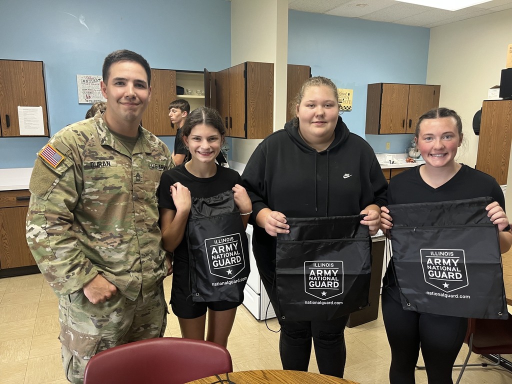 Pictured are three winners of the competition and the soldier. They are holding bags - their prizes.