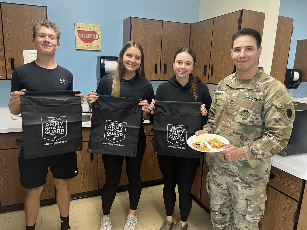 Pictured are three winners of the competition and the soldier. They are holding bags - their prizes.