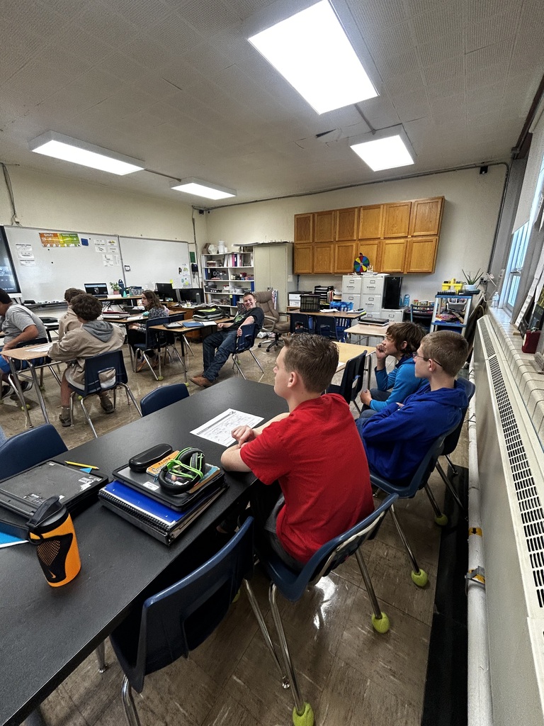 Students are in desks facing the SmartBoard.