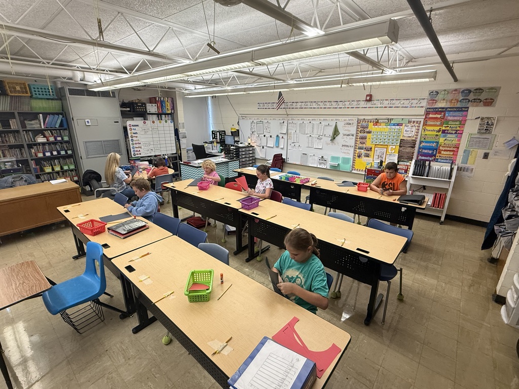 Students are cutting out construction paper. 