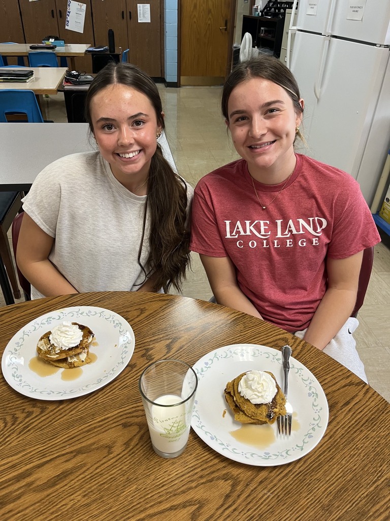 Two students are eating their pancakes.