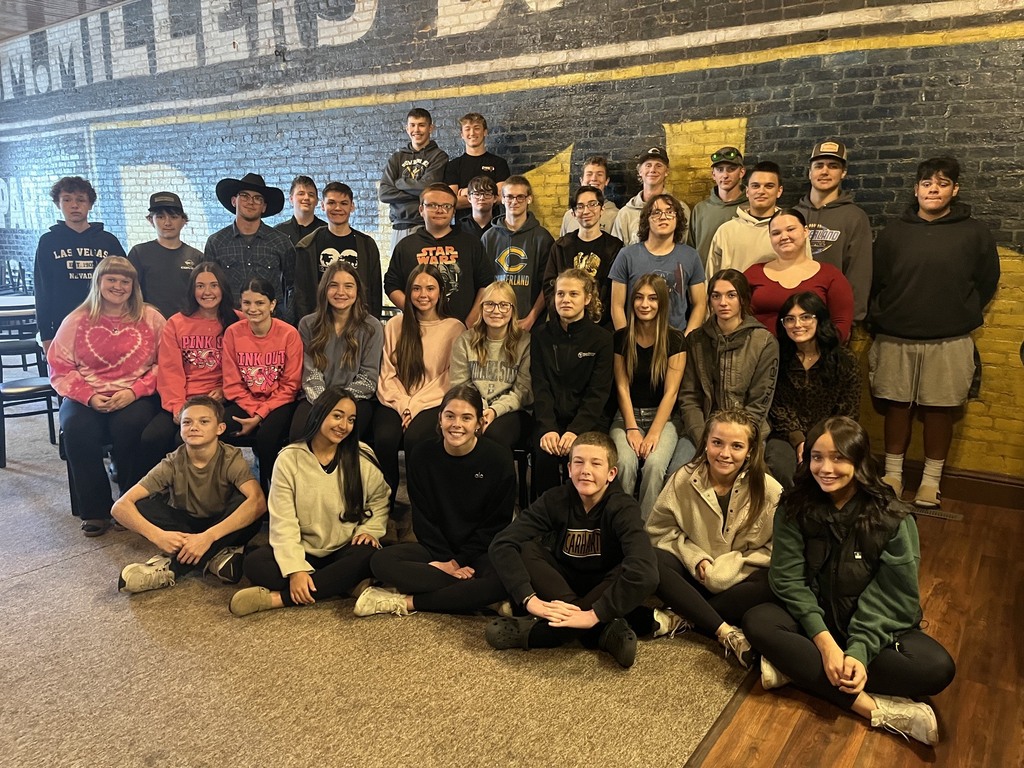 The group is sitting and standing in four rows posing for a picture.