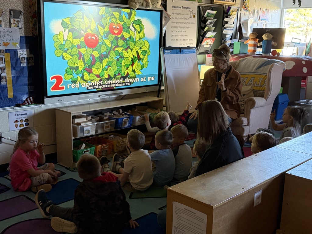 Students are singing a song about apples in a tree.