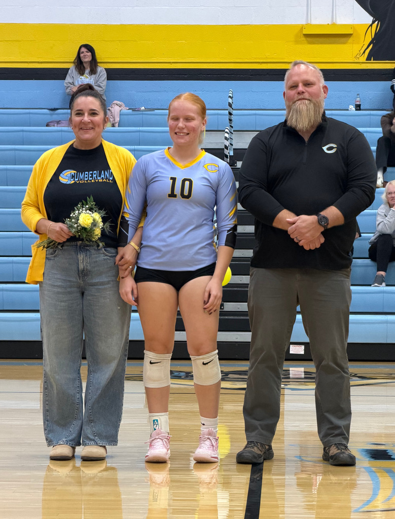 The player is standing on the court with parents. 
