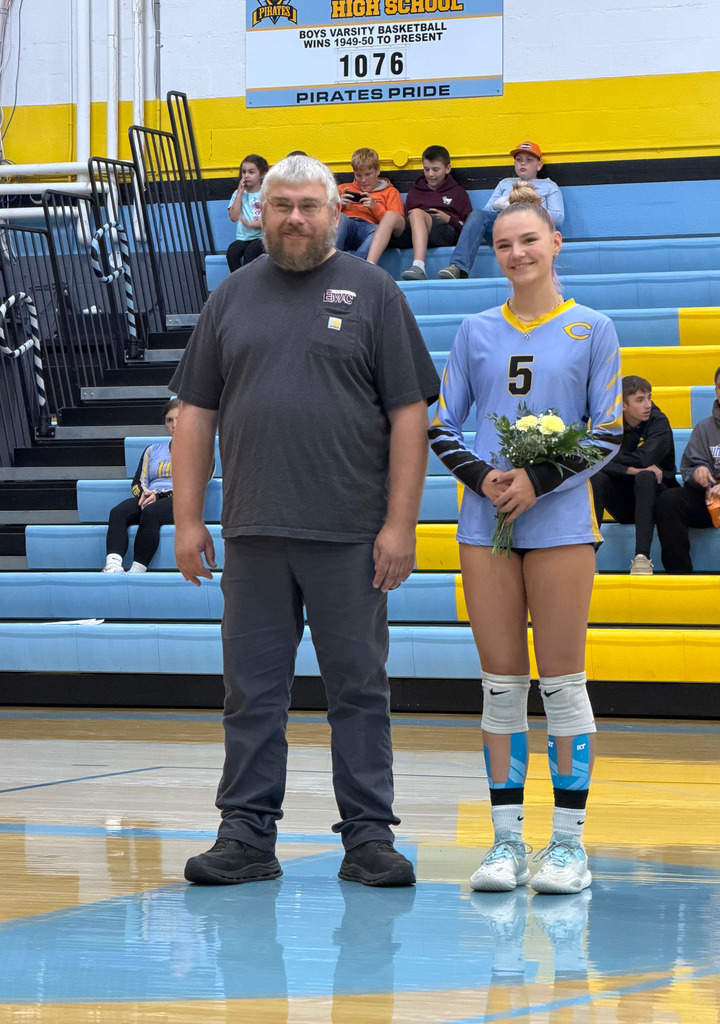 The player is standing on the court with parent. 
