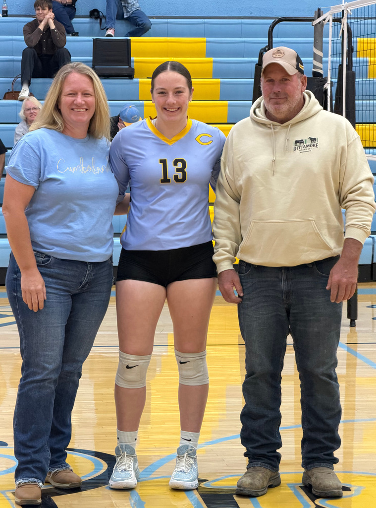 The player is standing on the court with parents. 