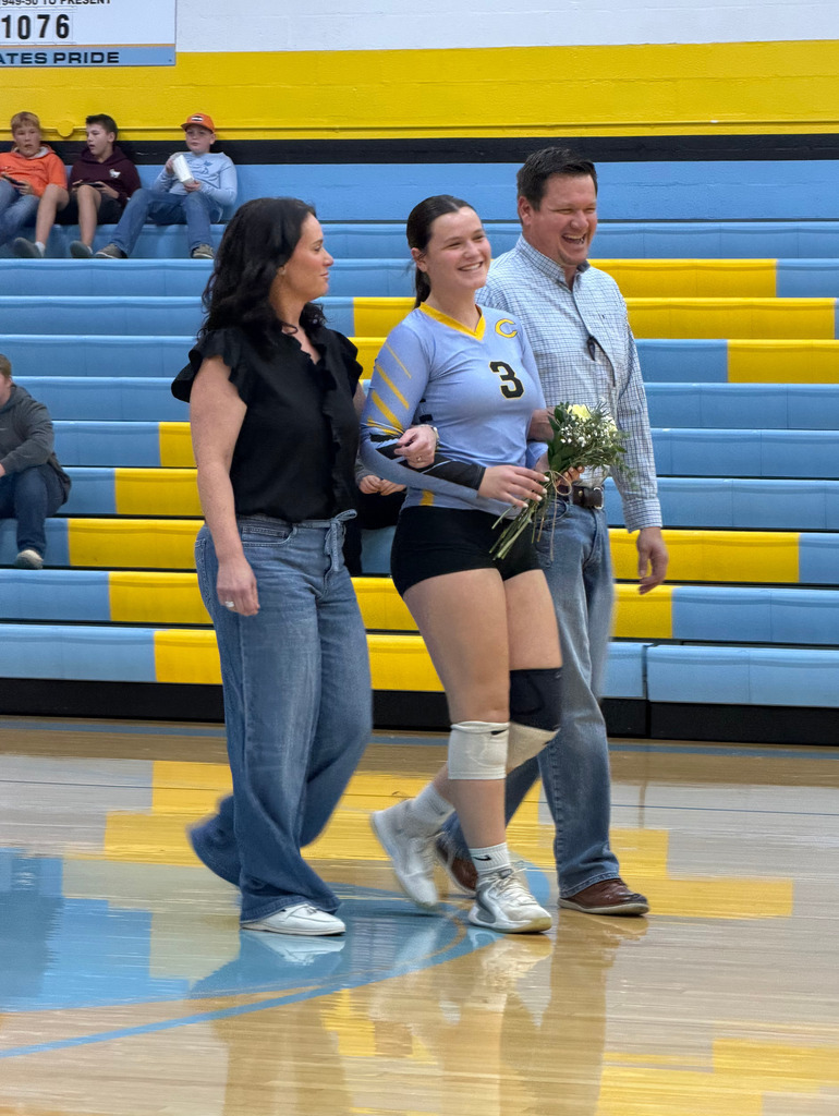 The player is standing on the court with parents. 