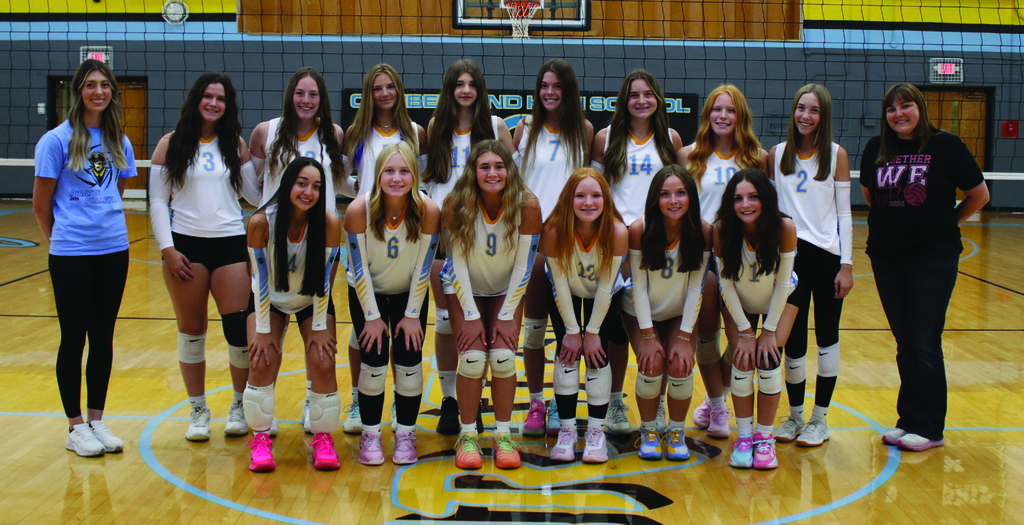 Pictured is the team dressed in white uniforms flanked by their coaches.