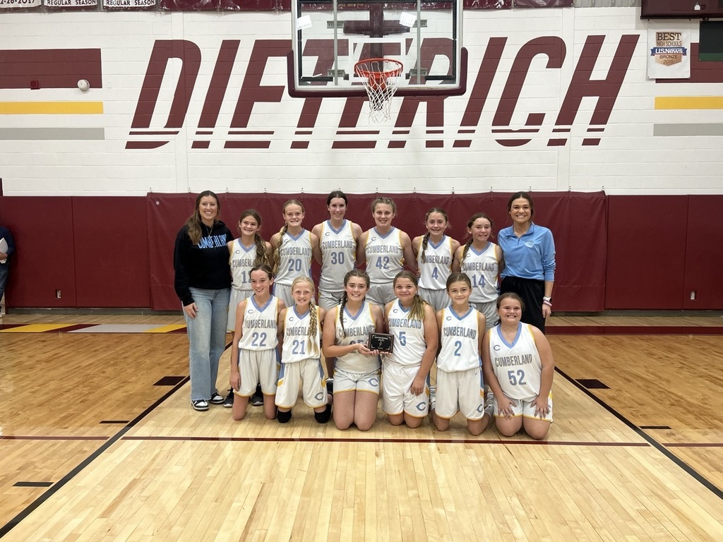 Pictured is the team in white uniforms flanked by the coaches. The team is holding the plaque.